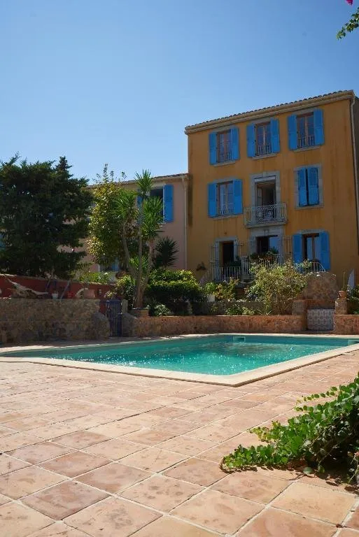 The yellow façade with blue shutters, above the pool